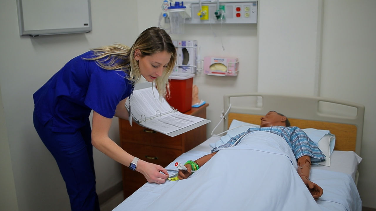 Nursing student attending to manikin