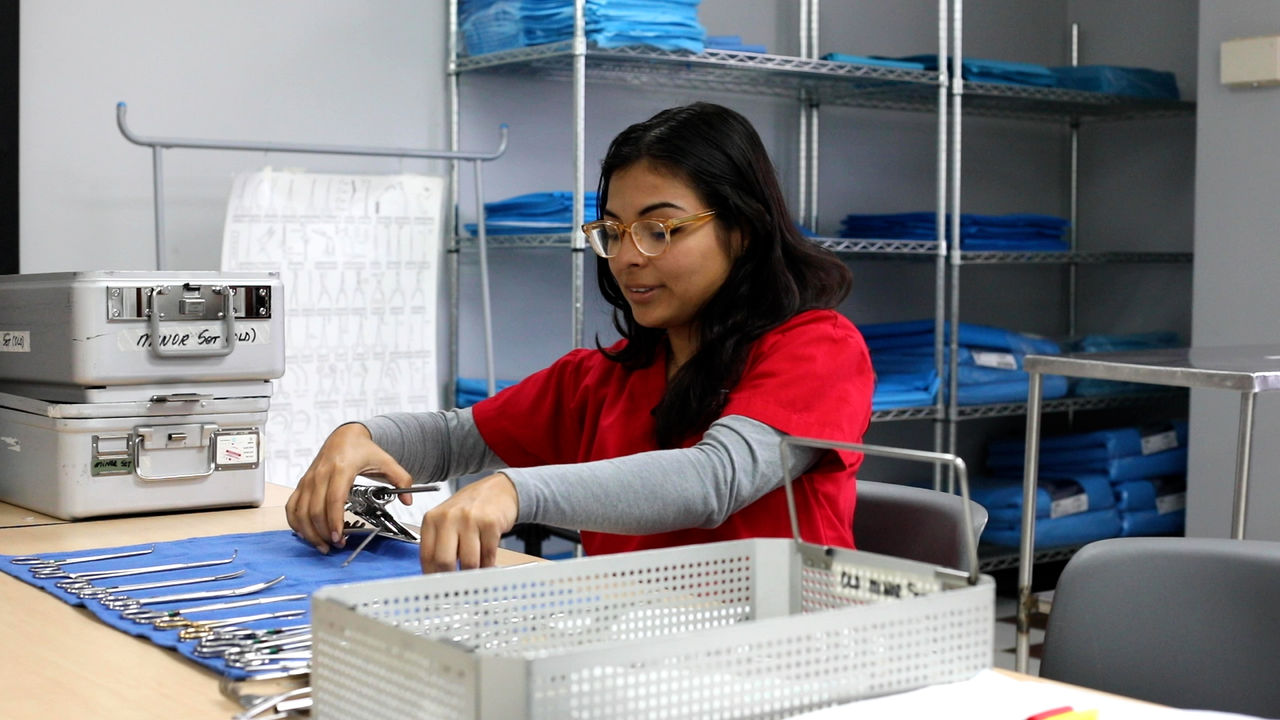 Medical staff organizing surgical instruments in sterile room
