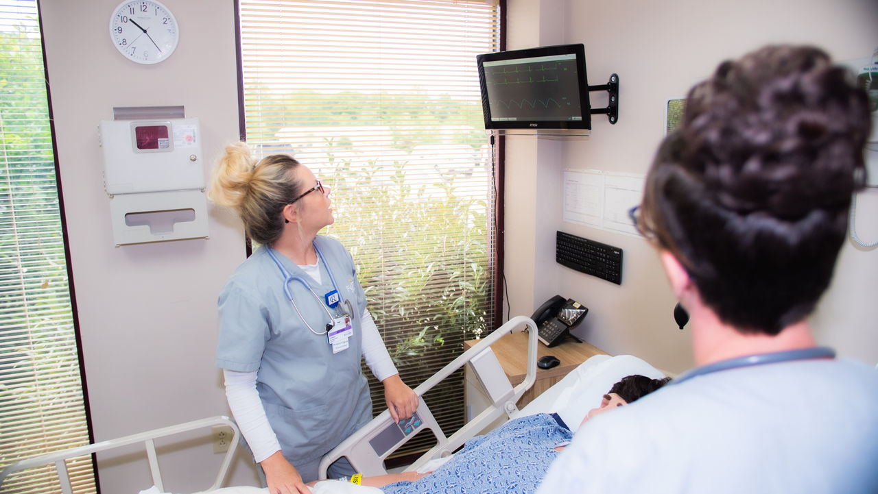 Nurses attending patient in modern hospital room