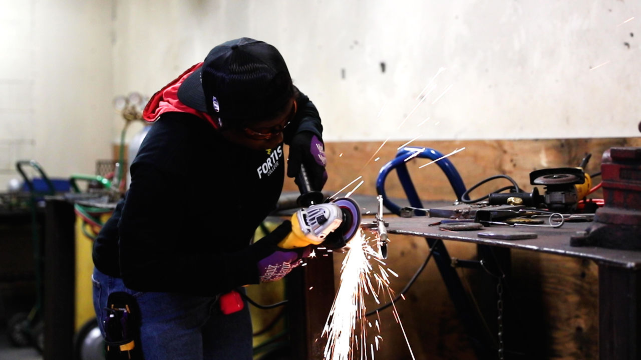Worker Using Angle Grinder in Industrial Workshop